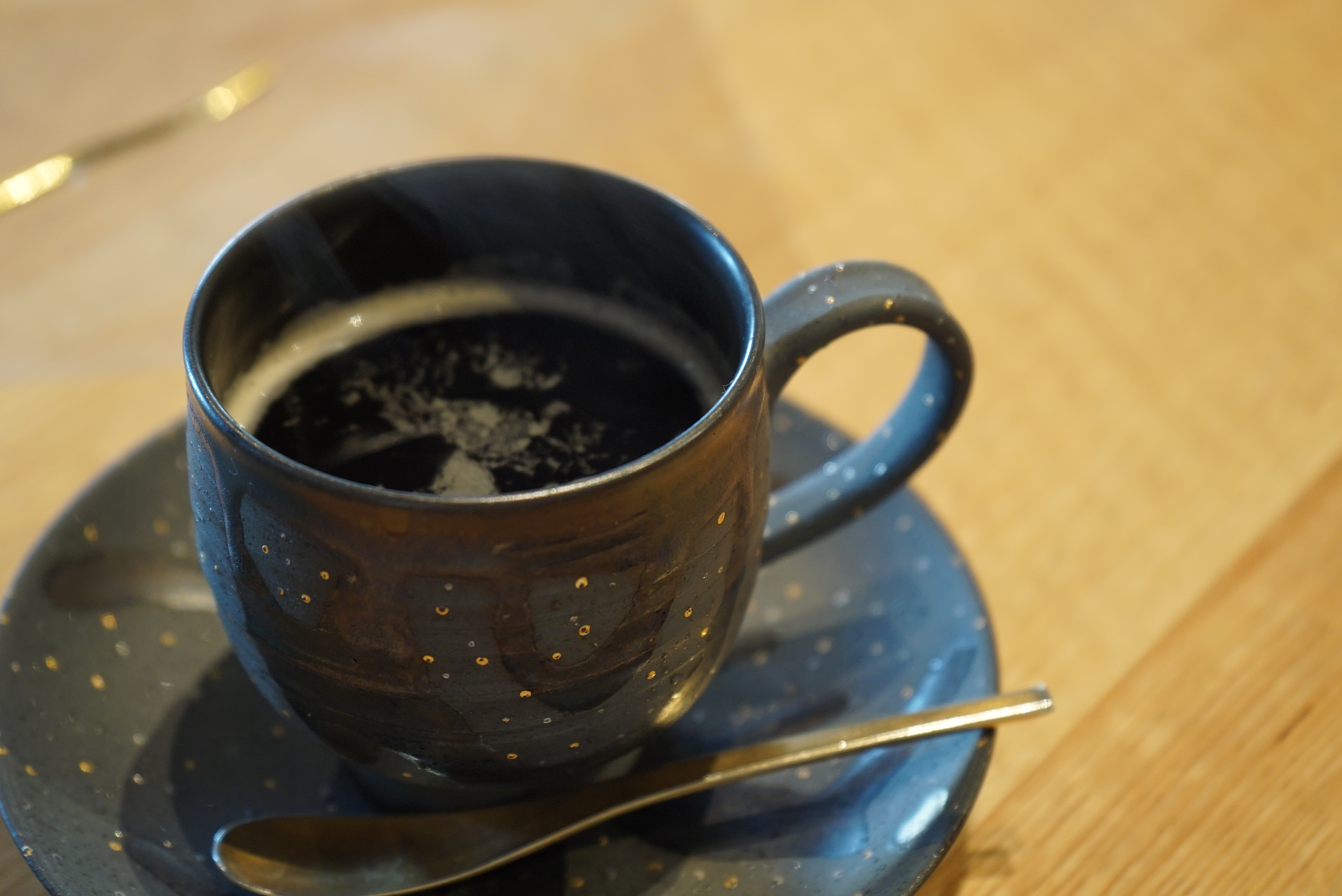 テーブルに置いているコーヒーとスプーン