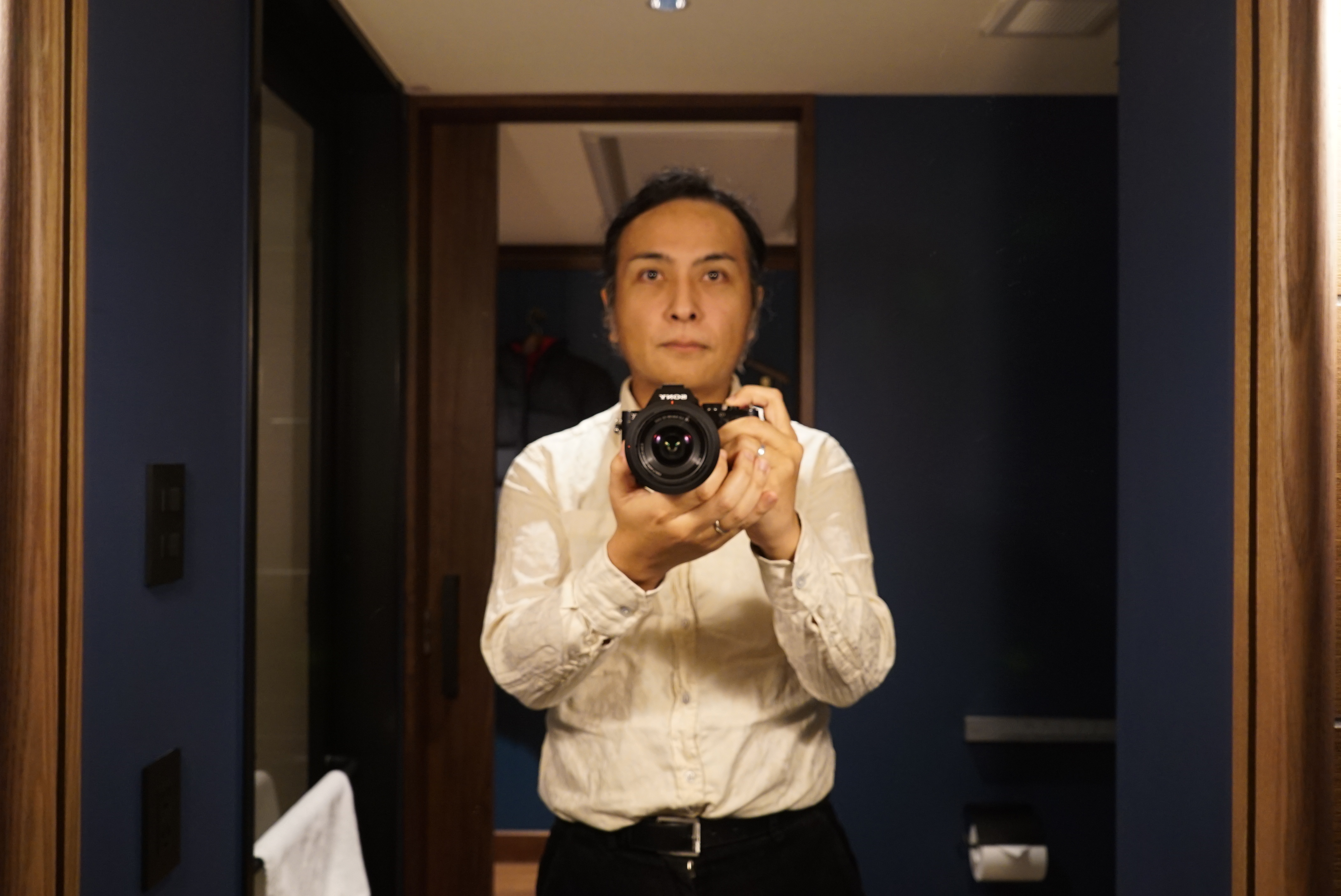鏡の前で電話をしている男性