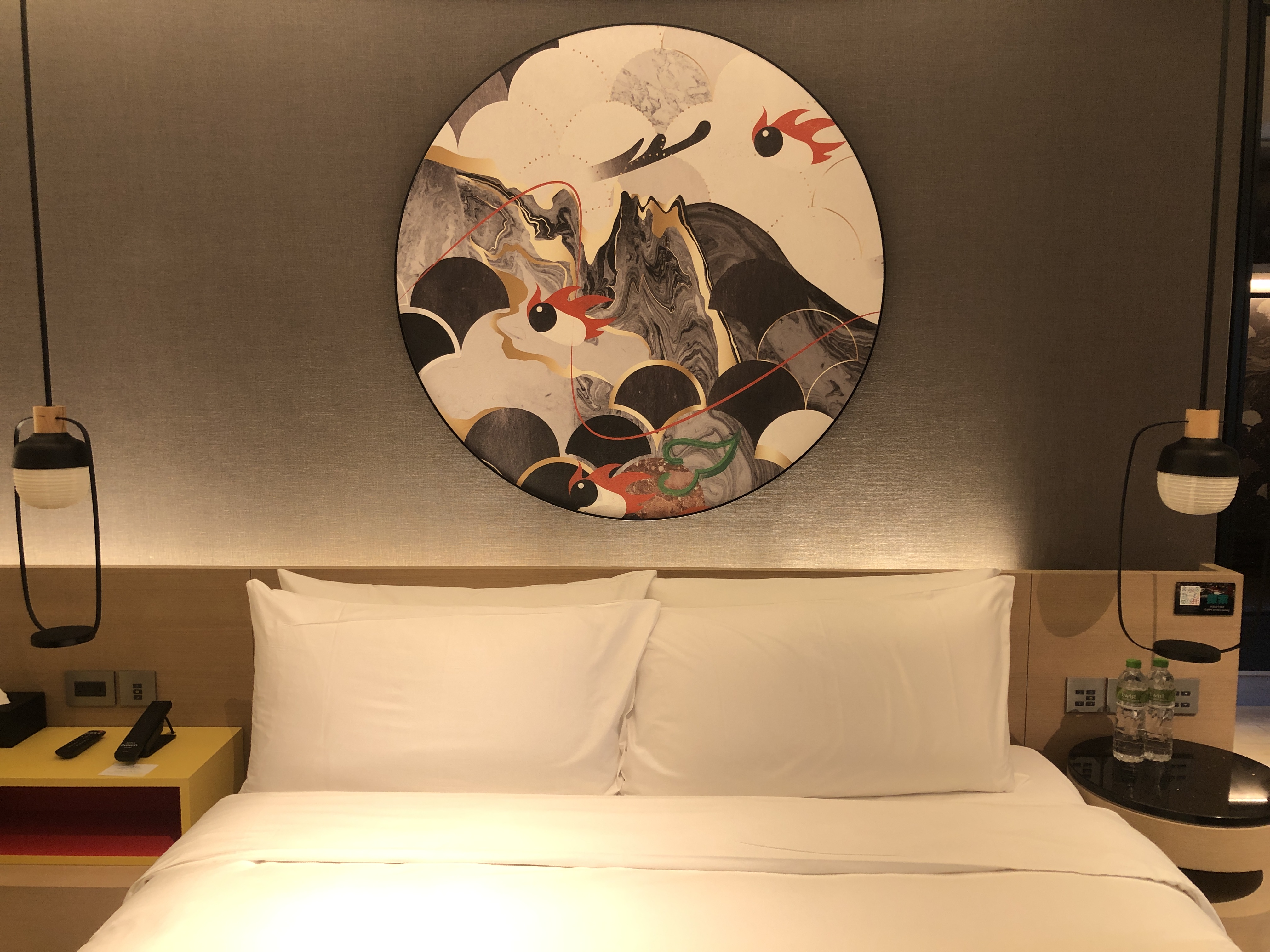 a bed with a round painting above it