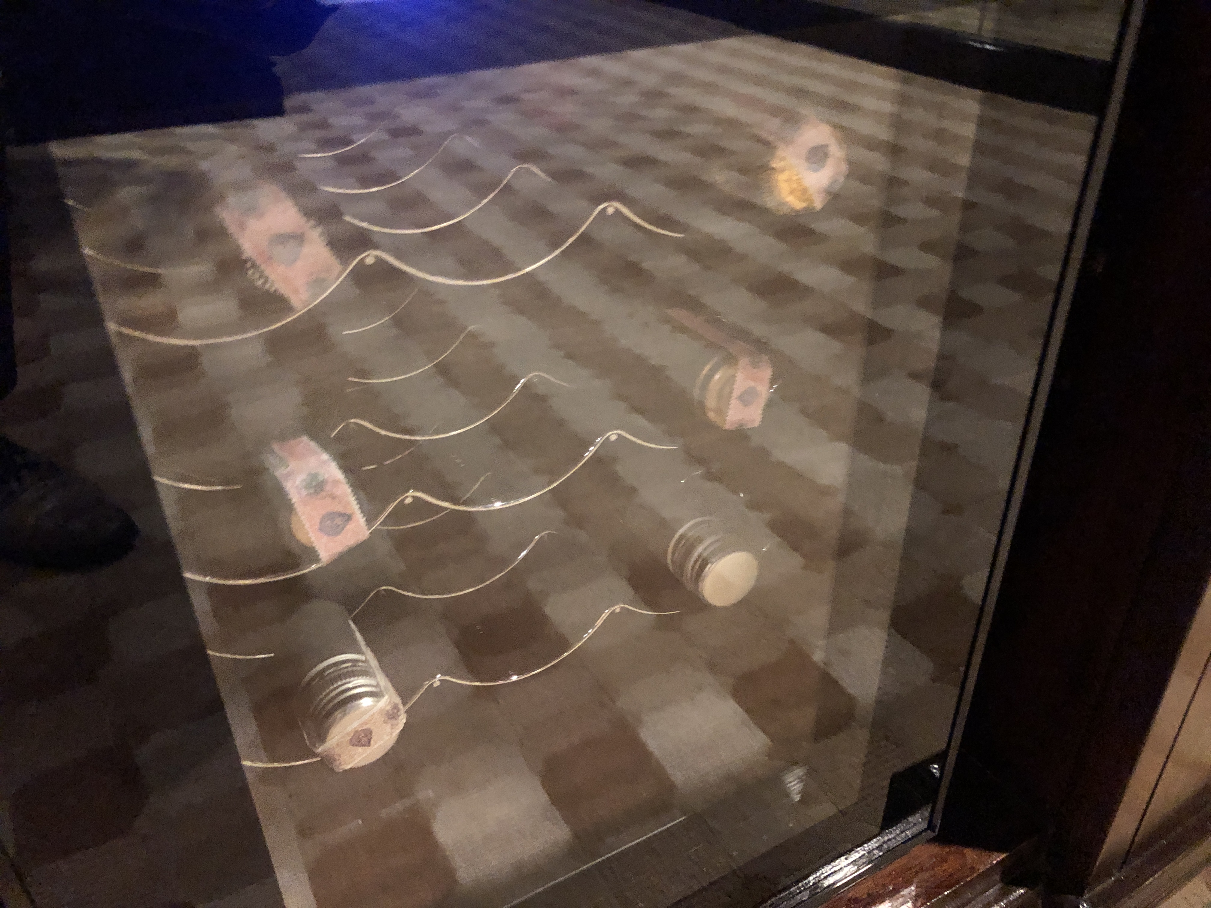 a glass case with wine bottles