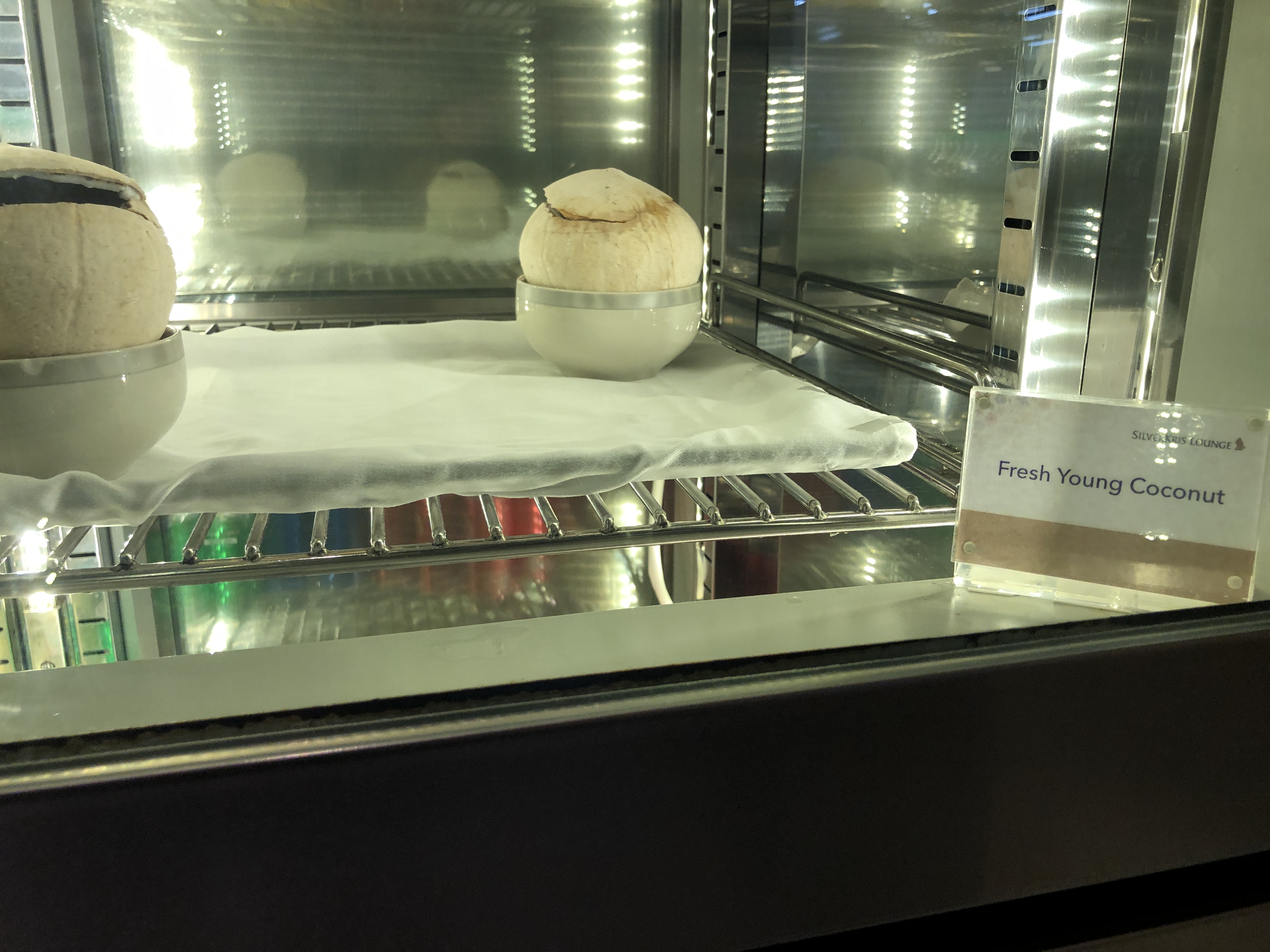 a white bowl with coconuts inside of a glass oven