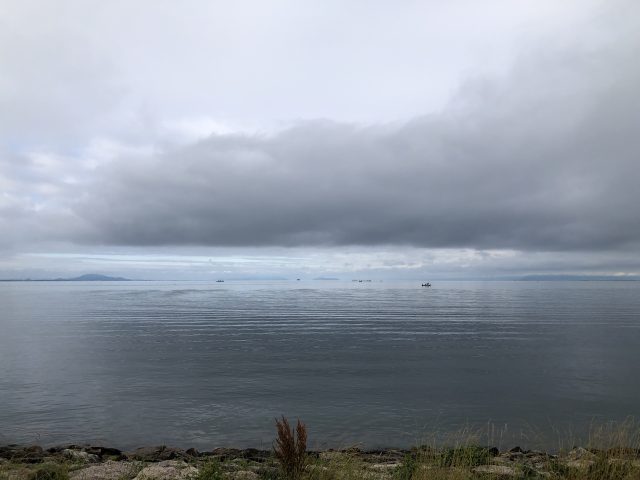 a body of water with a cloudy sky above it