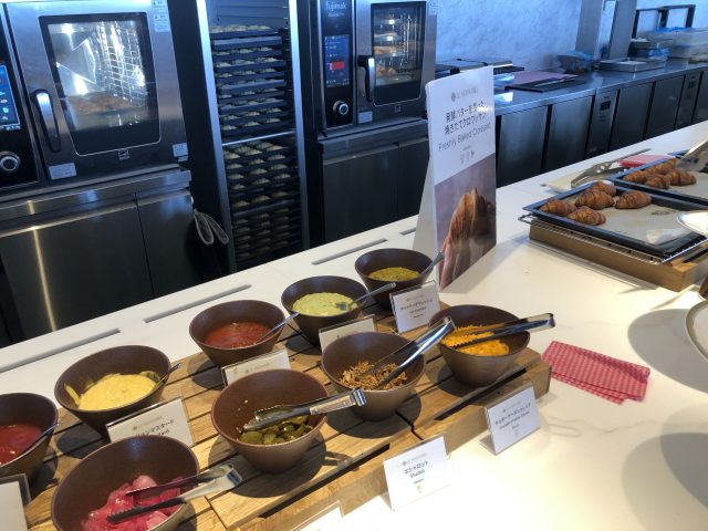 a kitchen counter with many bowls of food on it